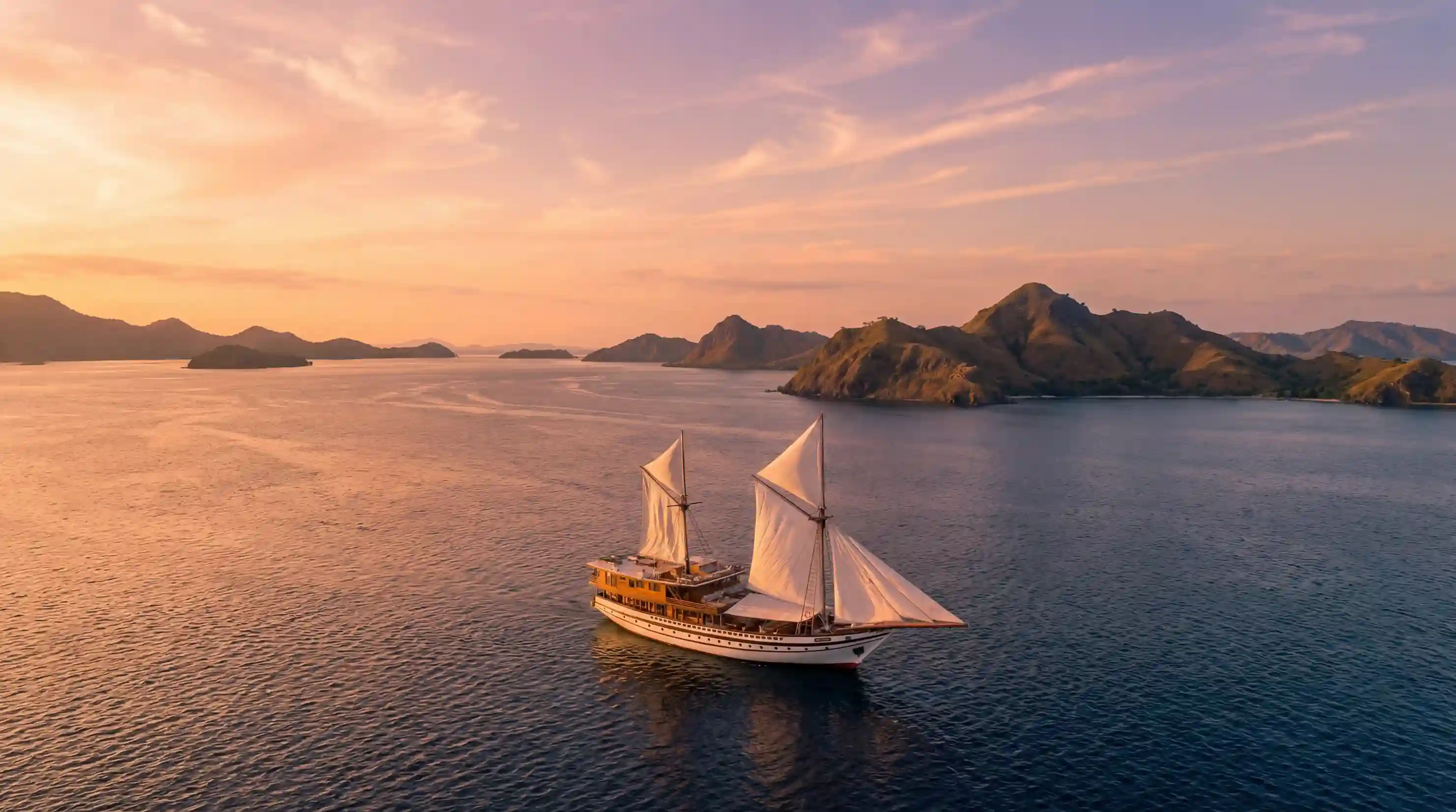 A phinisi at anchor among the Komodo islands at sunset